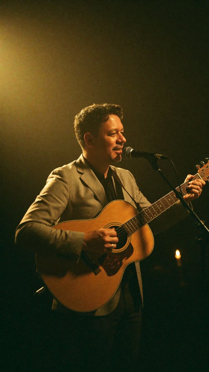 Auri Toledo cantando en un escenario íntimo de noche